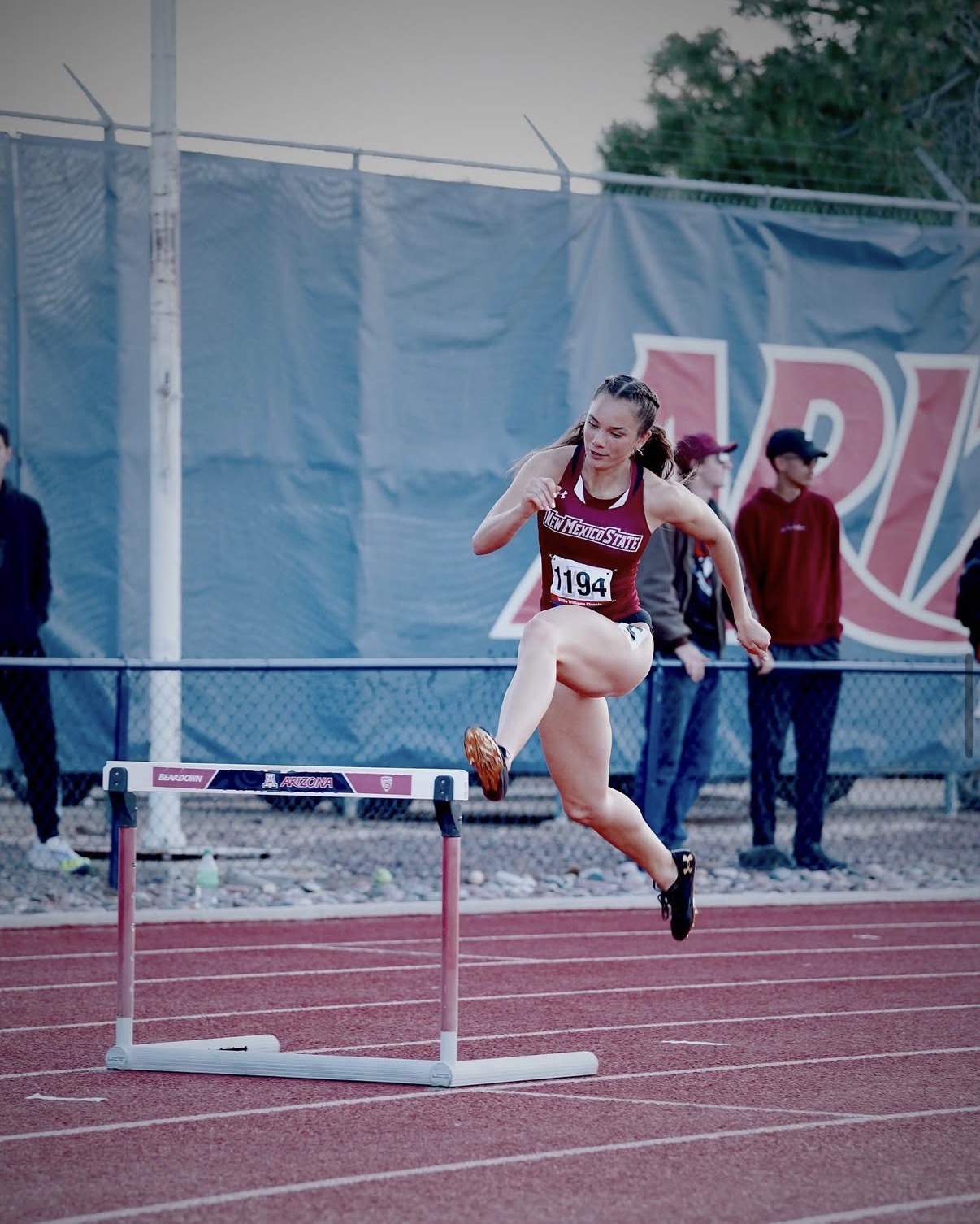 Israel clearing a hurdle at a dual meet